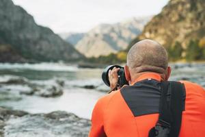 Landschaftsfotograf bei der Arbeit. fotograf schießt schöne aussicht auf die altai-berge des flusses katun foto