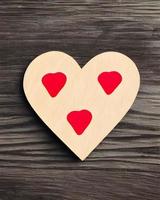 roter herzförmiger Liebesaufkleber auf Holztisch foto