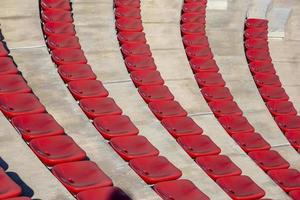 Reihen leerer roter Plastikstühle im Freilufttheater an einem sonnigen Tag. foto