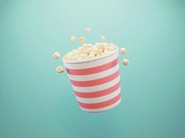 3D-Popcorn in rot-weiß gestreiftem Pappbecher auf hellblauem Hintergrund foto