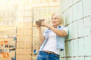 Porträt eines hübschen jungen Touristen, der mit einer Vintage-Retro-Kamera fotografiert foto