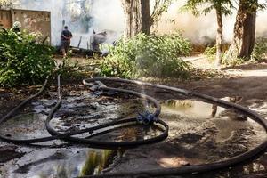 Feuerwehrschläuche liegen nach einem Brand am Boden foto