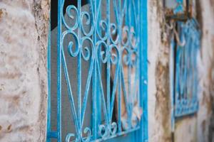 Metallgitter mit blauer Farbe auf einem alten Haus, selektiver Fokus auf Bars, Ideen für einen Hintergrund oder Innenraum, Renovierung alter Häuser foto