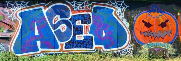 die alte mauer, gemalt in farbe graffiti zeichnung mit spraydosen. bild eines bösen und gruseligen orangefarbenen kürbisses, vorbereitet für halloween foto