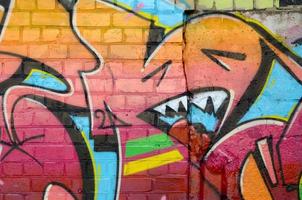 abstraktes buntes fragment von graffiti-gemälden auf alter backsteinmauer. Street-Art-Komposition mit Teilen wilder Buchstaben und bunten Flecken. subkulturelle Hintergrundtextur foto