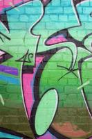 Abstraktes buntes Fragment von Graffiti-Gemälden auf alter Ziegelwand in grünen Farben. Straßenkunstkomposition mit Teilen ungeschriebener Buchstaben und mehrfarbiger Flecken. subkultureller Hintergrund foto