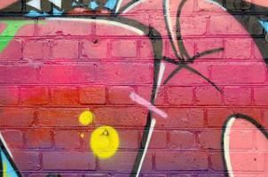 abstraktes buntes fragment von graffiti-gemälden auf alter backsteinmauer. Straßenkunstkomposition mit Teilen ungeschriebener Buchstaben und mehrfarbiger Flecken. subkulturelle Hintergrundtextur foto