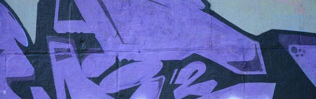 Fragment von Graffiti-Zeichnungen. Die alte Wand ist mit Farbflecken im Stil der Straßenkunstkultur dekoriert. farbige Hintergrundtextur in violetten Tönen foto