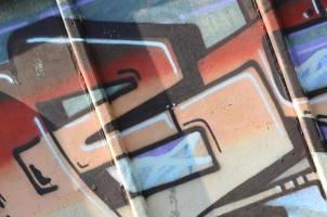 Fragment von Graffiti-Zeichnungen. Die alte Wand ist mit Farbflecken im Stil der Straßenkunstkultur dekoriert. farbige Hintergrundtextur in warmen Tönen foto