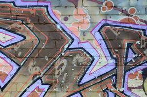 Fragment von Graffiti-Zeichnungen. Die alte Wand ist mit Farbflecken im Stil der Straßenkunstkultur dekoriert. farbige Hintergrundtextur in warmen Tönen foto