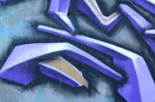 Fragment von Graffiti-Zeichnungen. Die alte Wand ist mit Farbflecken im Stil der Straßenkunstkultur dekoriert. farbige Hintergrundtextur in violetten Tönen foto