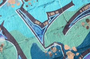 Fragment von Graffiti-Zeichnungen. Die alte Wand ist mit Farbflecken im Stil der Straßenkunstkultur dekoriert. farbige Hintergrundtextur in kalten Tönen foto