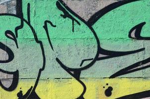 Fragment von Graffiti-Zeichnungen. Die alte Wand ist mit Farbflecken im Stil der Straßenkunstkultur dekoriert. farbige Hintergrundtextur in Grüntönen foto