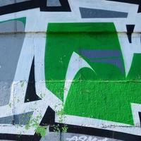 Fragment von Graffiti-Zeichnungen. Die alte Wand ist mit Farbflecken im Stil der Straßenkunstkultur dekoriert. farbige Hintergrundtextur in Grüntönen foto