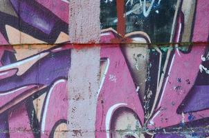 Fragment von Graffiti-Zeichnungen. Die alte Wand ist mit Farbflecken im Stil der Straßenkunstkultur dekoriert. farbige Hintergrundtextur in violetten Tönen foto