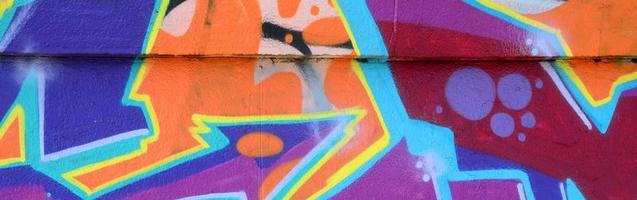 Fragment von Graffiti-Zeichnungen. Die alte Wand ist mit Farbflecken im Stil der Straßenkunstkultur dekoriert. farbige Hintergrundtextur in violetten Tönen foto