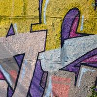 Fragment von Graffiti-Zeichnungen. Die alte Wand ist mit Farbflecken im Stil der Straßenkunstkultur dekoriert. farbige Hintergrundtextur in warmen Tönen foto