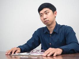 asiatischer mann ist traurig über die entlassenen mitarbeiter, die am arbeitstisch sitzen foto