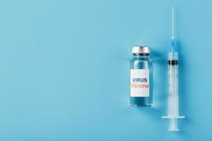 spritzen und ampulle mit dem impfstoff gegen das virus von krankheiten auf blauem hintergrund.