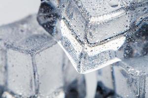 Eiswürfel mit Wassertropfen hautnah - in Makro auf weißem Hintergrund. erfrischendes Eis. isolieren foto