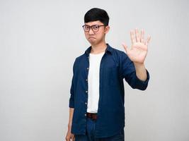 asiatischer mann, der eine brille trägt, zeigt die hand, um zu stoppen, nicht einverstanden zu sein foto