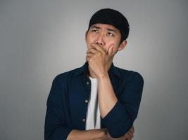 Deprimierter asiatischer Mann Kopfschmerzen und Weinen über sein Leben isoliert foto