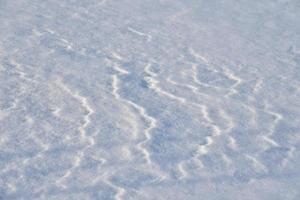 schneebedeckte Oberfläche. weißer Schnee und Schneeverwehungen im Winter. foto