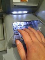 west java, indonesien im juli 2022. eine hand drückt die zifferntastatur eines geldautomaten foto