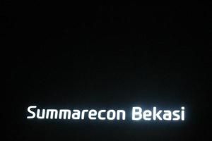 bekasi, indonesien im juli 2022. das summarecon bekasi logo leuchtet nachts hell vor dem dunklen nachthimmel. foto