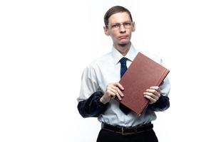 Ein Geschäftsmann mit Krawatte und Brille mit einer Zeitschrift in den Händen auf einem weißen, isolierten Hintergrund foto