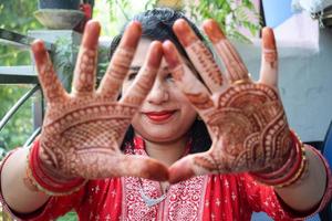 schöne frau, die sich als indische tradition mit henna-mehndi-design an beiden händen verkleidet hat, um das große fest von karwa chauth zu feiern, karwa chauth-feiern der indischen frau für ihren ehemann foto