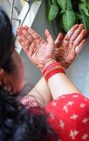 schöne frau, die sich als indische tradition mit henna-mehndi-design an beiden händen verkleidet hat, um das große fest von karwa chauth zu feiern, karwa chauth-feiern der indischen frau für ihren ehemann foto