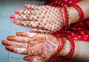 schöne frau, die sich als indische tradition mit henna-mehndi-design an beiden händen verkleidet hat, um das große fest von karwa chauth zu feiern, karwa chauth-feiern der indischen frau für ihren ehemann foto