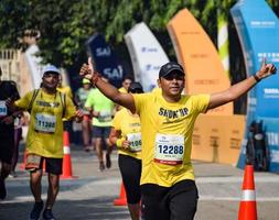 neu delhi, indien - 16. oktober 2022 - vedanta delhi halbmarathonrennen nach covid, bei dem die marathonteilnehmer kurz vor dem überqueren der ziellinie stehen, delhi halbmarathon 2022 foto