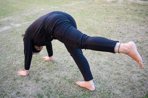 junge indische Frau, die Yoga im Freien in einem Park praktiziert. schönes Mädchen üben grundlegende Yoga-Pose. Ruhe und Entspannung, weibliches Glück. Grundlegende Yoga-Posen im Freien foto