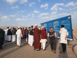 medina, saudi-arabien, dezember 2022 - abendlicher blick auf den historischen friedhof jannat al-baqi in medina. pilger aus verschiedenen ländern der welt befinden sich in der nähe der leittafel auf dem friedhof jannat al baqi. foto