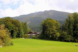 reise nach sankt-wolfgang, österreich. der blick auf die grüne wiese mit den häusern und den bergen im hintergrund. foto
