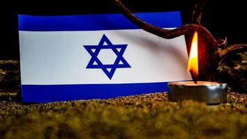 israelische flagge und davor brennende kerzen, holocaust-gedenktag foto