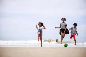 Gruppe von Freunden aus der Kindheit, die glücklich an einem tropischen Strand springen. ethnisch vielfältiges Konzept foto