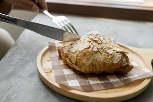 frisch gebackene Croissants mit Mandeln auf der modernen Holzplatte im Café. foto