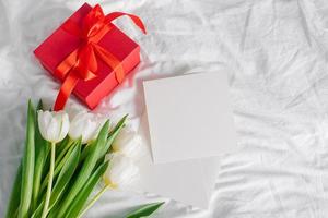 Tulpenblumen, rote Geschenkbox und leere Karte für Text. Attrappe, Lehrmodell, Simulation. konzept des frauentages, muttertags foto