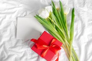 Tulpenblumen, rote Geschenkbox und leere Karte für Text. Attrappe, Lehrmodell, Simulation. konzept des frauentages, muttertags foto