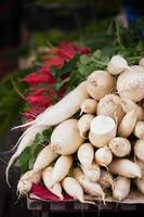 Weiße Radieschen stapeln sich auf einem Markt foto