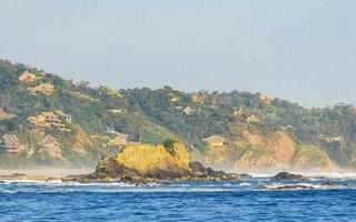 mazunte mexiko schöner paradiesstrand mit bergfelsen felsen wellen. foto