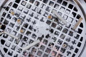 Draufsicht und Nahaufnahme Stahlaschenbecher mit gebrauchter Zigarette. foto