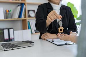 Immobilienmakler geben dem Hausbesitzer den Schlüssel nach Kauf-Verkaufs-Vereinbarung. foto