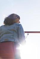 Eine infantile und glückliche Frau, die auf einer Kinderrutsche auf einem Spielplatz sitzt foto