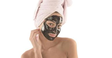 frau mit maske im gesicht im spa-schönheitssalon foto