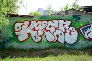 Straßenkunst. abstraktes Hintergrundbild eines vollständig fertiggestellten Graffiti-Gemäldes in Chromfüllung, grünem Hintergrund und roten Umrissen foto