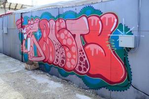 Straßenkunst. abstraktes Hintergrundbild eines vollständig fertiggestellten Graffiti-Gemäldes in Rosa- und Rottönen mit einer Zeichentrickfigur foto